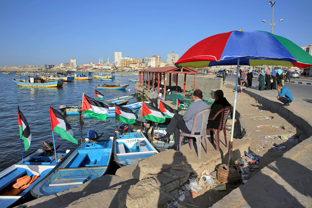 In this April 17 file photo, Palestinians protect themselves from the sun at the fishermen port in Gaza City (AP photo)