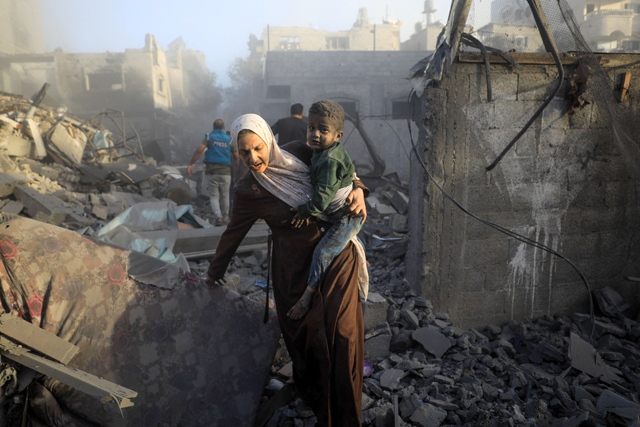 People flee following Israeli air strikes on a neighbourhood in the Al Maghazi refugee camp in the central Gaza Strip on Monday, amid ongoing Israeli bombardment of the coastal enclave (AFP photo)