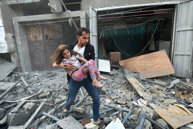 A Palestinian man carries away an injured child from a home that was hit in an Israeli strike on the Jabalia refugee camp in the northern Gaza Strip, on November 7, 2024 (AFP photo)