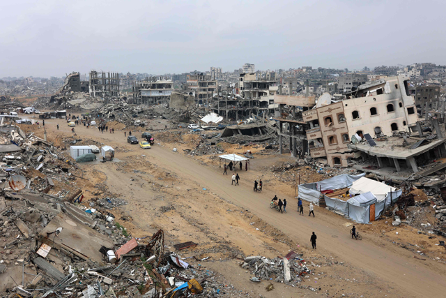 People walk amid collapsed buildings along Saftawi street in Jabalia in the northern Gaza Strip on February 5, 2025 during a ceasefire deal in the war between Israel and Hamas (AFP photo)