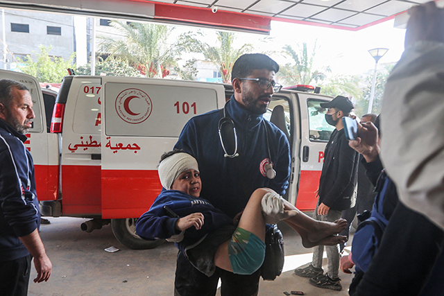 An injured Palestinian child is carried into a hospital following Israeli bombardment on Khan Yunis in the southern Gaza Strip on Friday (AFP photo)