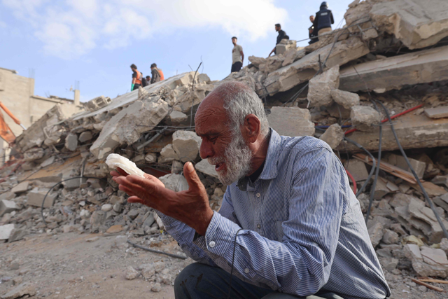 A Palestinian man wait for news of his daughter as rescue workers search for survivors under the rubble of a building hit in an overnight Israeli bombing in Rafah, in the southern Gaza Strip, on Sunday (AFP photo)
