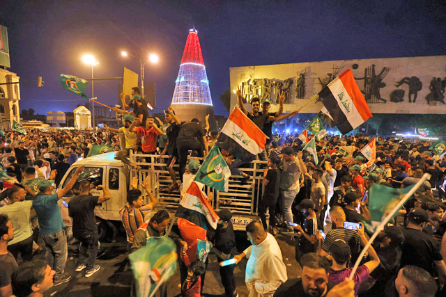 Supporters of Iraqi Shiite cleric Moqtada Al Sadr celebrate in Baghdad's Tahrir Square on Monday following the announcement of parliamentary election results (AFP photo)