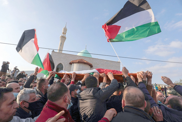Mourners carry the body of Palestinian Atef Yussef Hanaysheh, who was shot dead by Israeli soldiers, during his funeral in the village of Beit Dajan in the Israeli-occupied West Bank on Friday (AFP photo)