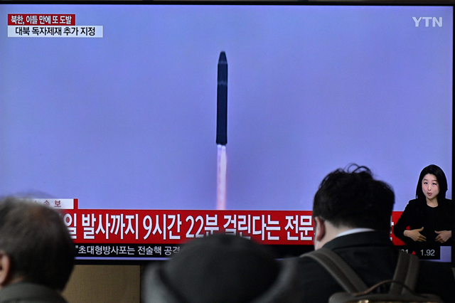 People sit near a television showing a news broadcast with file footage of a North Korean missile test, at a railway station in Seoul on Modnay  (AFP photo)