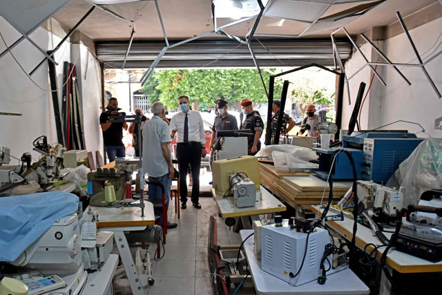 Lebanon's newly-appointed Prime Minister Mustapha Adib (centre) speaks with the owner of a damaged shop during a tour in Beirut's badly-hit Gemmayzeh neighbourhood, on Monday (AFP photo)