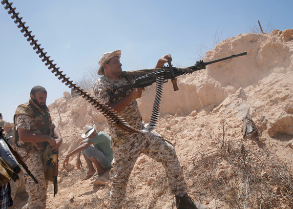 A fighter of Libyan forces allied with the UN-backed government fires a weapon during a battle with Daesh fighters in Sirte, Libya, on Thursday (Reuters photo)