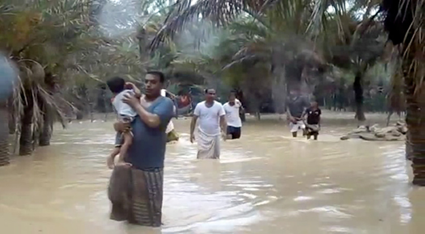 An image grab taken from an AFP TV video shows people walking through floodwater as they evacuate a flooded area during a cyclone in the Yemeni island of Socotra (AFP photo)
