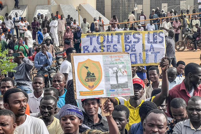 Protesters hold a banner in support of the Niger junta during a demonstration on independence day in Niamey on Thursday (AFP photo)