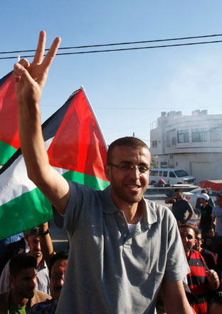 This file photo taken on May 19, 2016 shows Palestinian journalist Mohammed Al Qiq, who was held by Israel without trial and went on hunger strike for more than three months, flashing the ‘V’ for victory sign as he arrives in the village of Dura near Hebron, in the occupied West Bank, following his release from the Israeli Nafha Prison on May 19, 2016 (AFP photo)