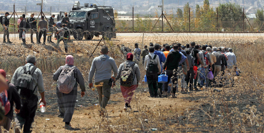 Palestinian labourers, who work in Israel, walk to cross through a hole in a security fence in the village of Muqeibila near the West Bank town of Jenin on Monday, following the closure of Al Jalama checkpoint (AFP photo)