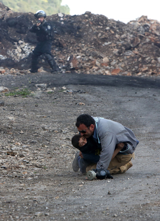This file photo taken on March 4, 2016 shows a Palestinian man attempting to pick up a boy after he was injured by Israeli security forces following a demonstration against the expropriation of Palestinian land by Israel, in the village of Kfar Qaddum, near Nablus in the occupied West Bank (AFP photo)