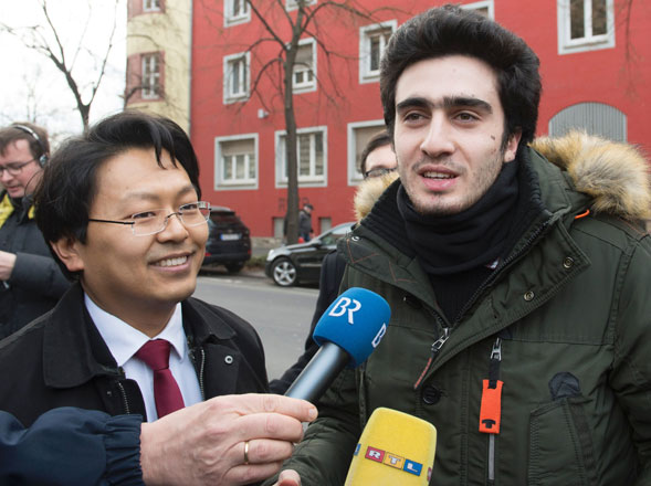 Syrian refugee Anas Modamani (right) and his lawyer Chan-jo Jun talk to the media on their way to the district court in Wuerzburg, southern Germany, on Monday (AFP photo)