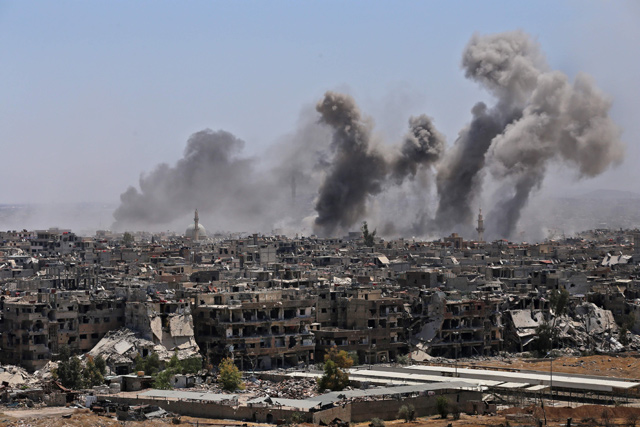 This photo taken during a government guided tour shows smoke rising from buildings in Yarmouk, a Palestinian refugee camp on the edge of Damascus, during regime shelling targeting Daesh group positions in the southern district of the capital, on Tuesday (AFP photo)