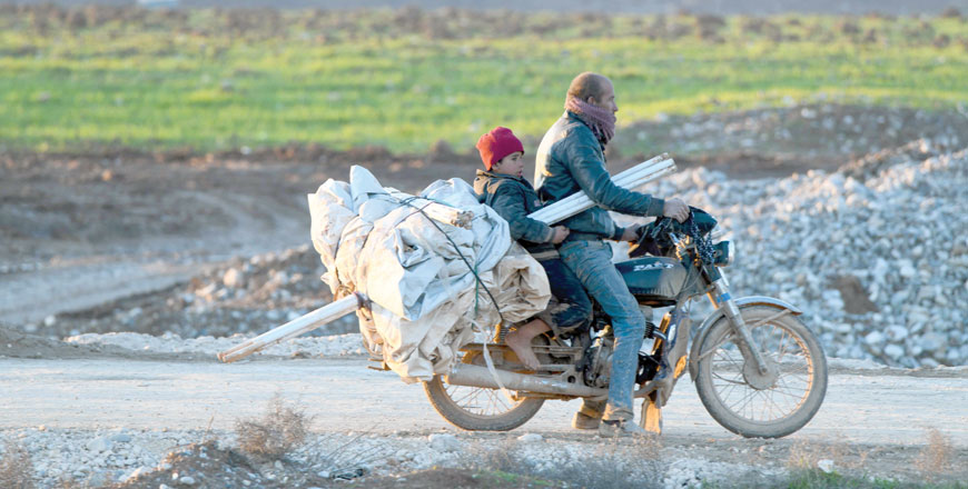 A man, riding his motorcycle with a child, arrives at a camp for the internally displaced near Dayr Ballut, near the Turkish border in the rebel-held part of Aleppo province on Sunday (AFP photo)