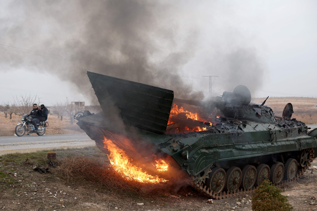 A military vehicle belonging to the Syrian regime forces and seized by anti government forces burn after it was hit by regime forces in the Hama governorate, on December 7, 2024 (AFP photo)