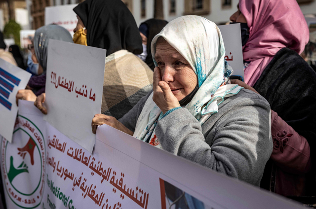 A member of the coordination of the families of Moroccans detained or stranded in Syria and Iraq, who are accused of having travelled to join the Daesh terror group, hold placards during a demonstration to demand their rapatriation, in the capital Rabat, on Friday (AFP photo)