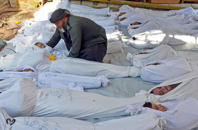 A man holds the body of a dead child among bodies of people activists say were killed by nerve gas in the Ghouta region, in the Duma neighbourhood of Damascus, Syria, August 21, 2013 (Reuters photo)