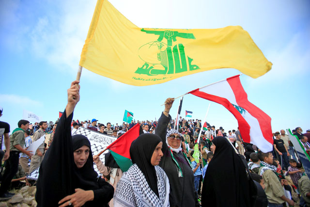 Lebanon's Hizbollah supporters wave flags during a rally to mark the 70th anniversary of Nakba near Beaufort Castle in Yehmor, Lebanon, on Tuesday (Reuters photo)