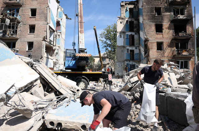 Volunteers clear the rubble of a destroyed building following a rocket attack the day beofre, in Kyiv, on Tuesday, amid the Russian invasion in Ukraine (AFP photo)