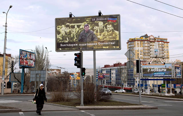 This file photo taken on March 18, 2015, shows a woman walking under a billboard featuring a photo of the leader of the self-proclaimed Donetsk People's Republic Alexander Zakharchenko (centre) and reading: ‘We are grateful to the defenders of the fatherland’ in Donetsk (AFP photo)