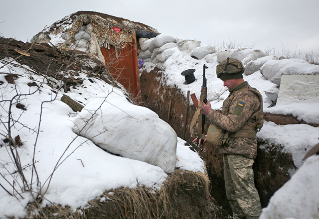 An Ukrainian serviceman checks his weapon as he stands in a trench on the frontline with the Russia-backed separatists near Zolote village, in the eastern Lugansk region, on Friday (AFP photo)