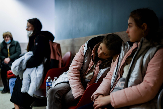 Ukrainian refugees wait for an appointment in a centre for the registration and shelter set at the former Jules Bordet Hospital in Brussels, on Tuesday (AFP photo)