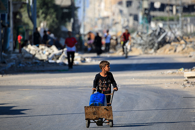 A boy carries water Al Bureij refugee camp in the central Gaza Strip on June 24, 2024, amid the ongoing Israeli war on the Palestinian territory (AFP photo)