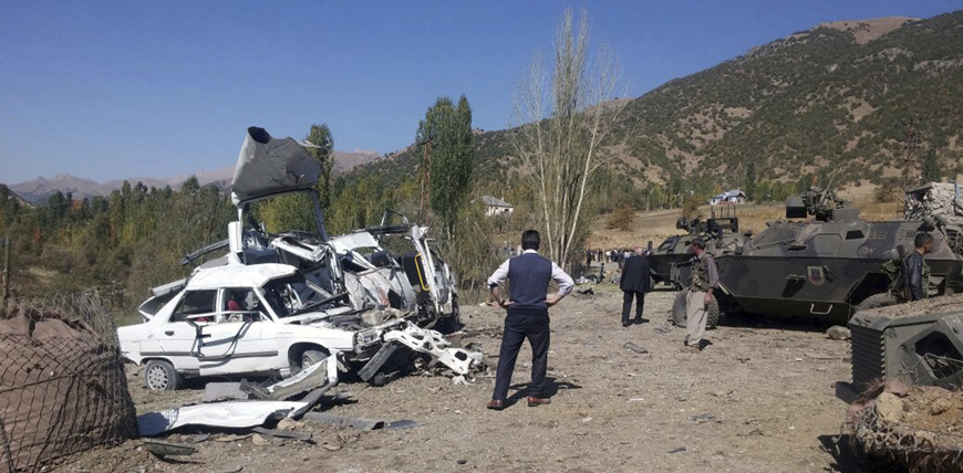Soldiers, security members and people work at the scene of a car bomb attack in Semdinli, near the border with Iraq,  Turkey, on Sunday (AP photo)