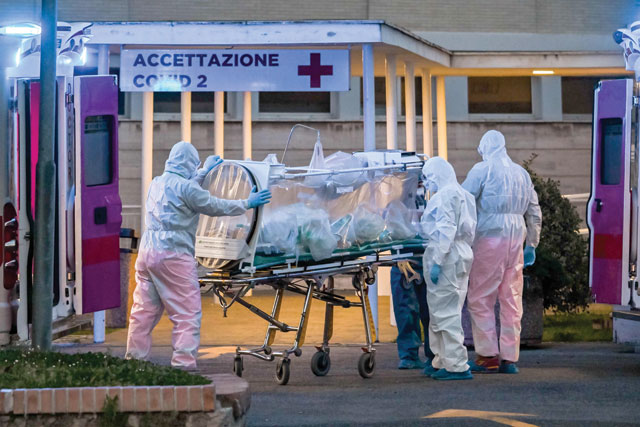Medical workers in overalls stretch a patient under intensive care into the newly built Columbus Covid 2 temporary hospital to fight the new coronavirus infection, on Monday, at the Gemelli Hospital in Rome (AFP photo)