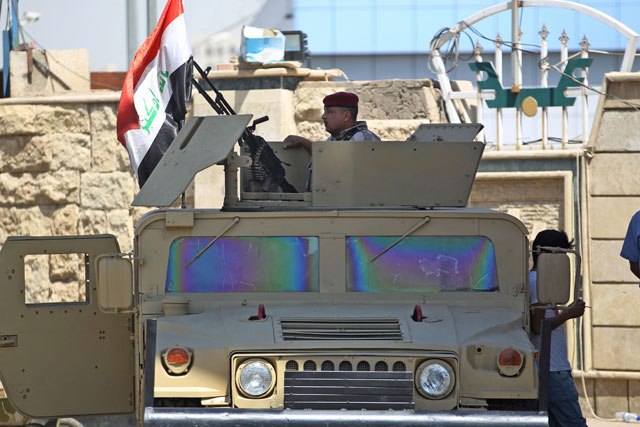 A member of the Iraqi security forces mans a turret in a humvee outside a warehouse where  ballots from the May parliamentary election are stored in the capital Baghdad on Monday, as the electoral commission continued a partial recount of ballots in areas where allegations of fraud were reported (AFP photo)