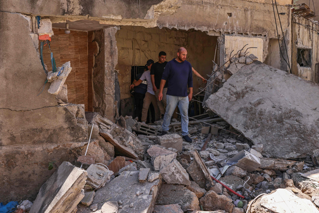 Palestinians inspect a damaged building at the site of an Israeli army raid in Tubas city in the occupied West Bank on August 14, 2024 (AFP photo)