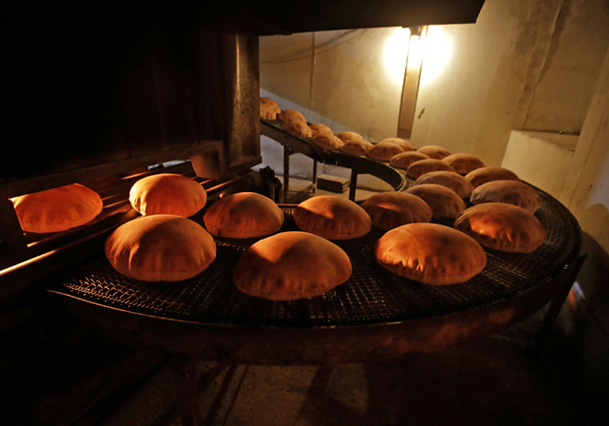 In this file photo taken on July 1, 2020, freshly-baked bread moves along a production line out of an oven at an automated bakery in Lebanon's capital Beirut. Russia's invasion of Ukraine could mean less bread on the table in Egypt, Lebanon, Yemen and elsewhere in the Arab world where millions already struggle to survive (AFP photo)