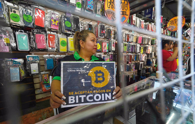 A vendor holds a sign reading 'Bitcoin accepted' at a store in San Salvador, on Wednesday (AFP photo)