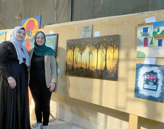 Sisters Isra and Islam Eid pose for a photo next to their creations at the Gilgamesh Art Cafe Exhibition last week  (Photo by Artemis Sianni-Wedderburn)