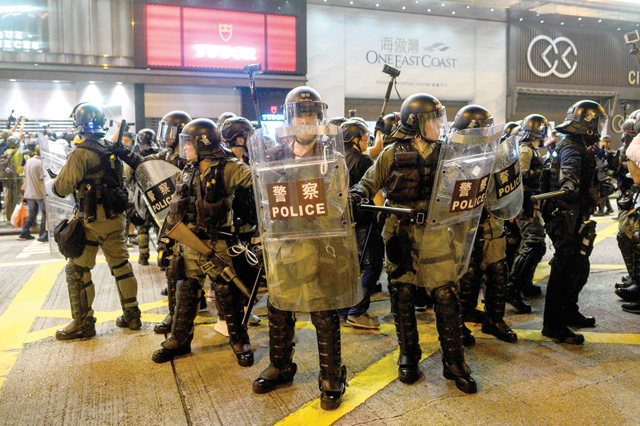 A group of riot police stand guard on a main road during a protest in Mong Kok district in Hong Kong on Saturday (AFP photo)