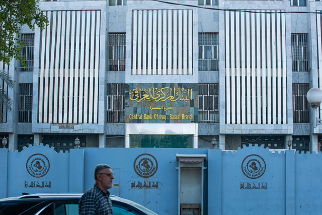A man walks in front of the local branch of Iraq's central bank in the southern city of Basra, on December 8 (AFP photo)