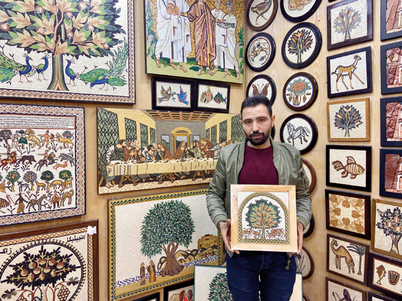 Mike Coper, a mosaic artist, poses for a photo at his shop in Madaba (Photo by Jocelyn Chau)