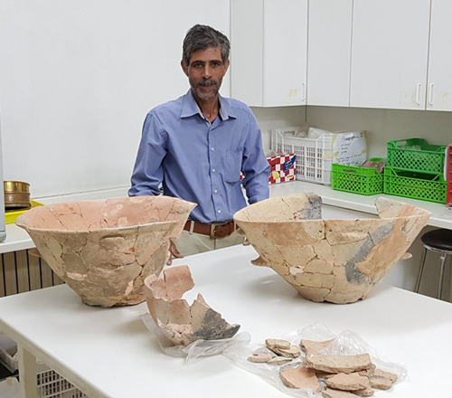   Conservation Technician Naif Zaban works for the ACOR Conservation Cooperative. Here he is with the Early Bronze Age vessels he conserved from Khirbet Al Murayghat. They were excavated by Dr Susanne Kerner of the University of Copenhagen (Photo courtesy of Barbara Porter)