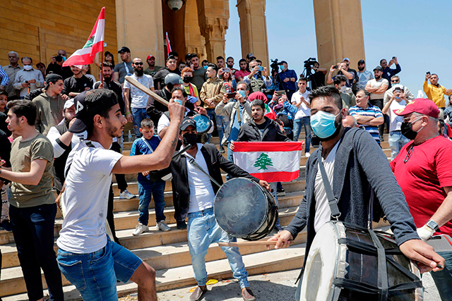 Lebanese anti-government protesters bang on drums and dance during a demonstration against the growing economic hardship in the downtown area of Beirut on May 1, marking Labour Day (AFP photo)