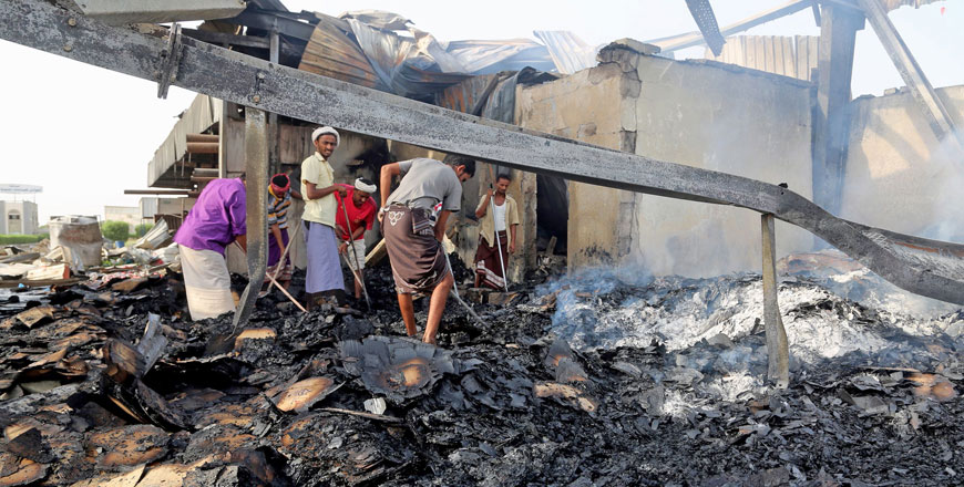 Yemeni men inspect damages at a factory allegedly targeted by Saudi-led coalition’s air strikes in the Red Sea town of Hodeida on Friday (AFP photo)