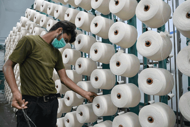 In this photo taken on July 20, a textile worker arranges thread rolls at Kohinoor Mills in Lahore (AFP photo)