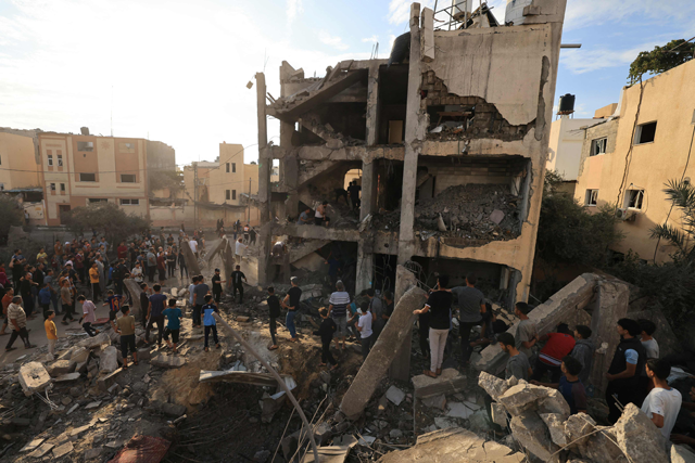 Palestinians search through the rubble of a building after an Israeli strike in Khan Yunis in the southern Gaza Strip on Tuesday (AFP photo by Mahmud Hams)