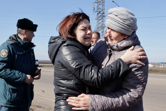 An evacuee from the settlement of Goncharovka on the outskirts of Sudzha (right) reacts meeting a relative at a Russian emergencies ministry aid spot at a military checkpoint west of Kursk on the highway towards Sudzha, on Monday (AFP photo)