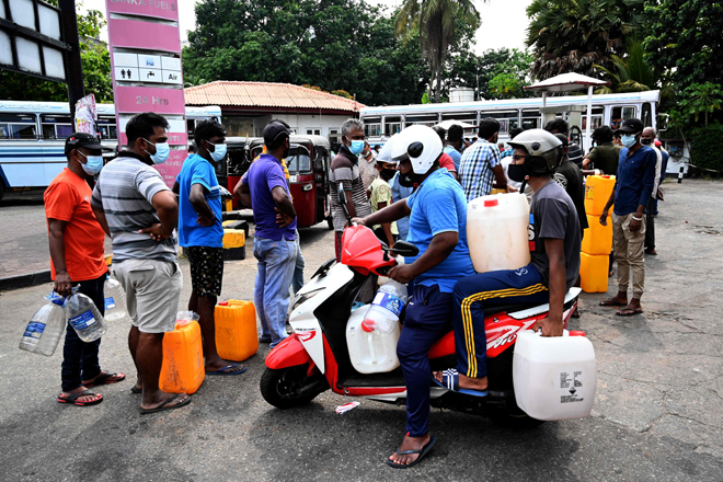People stand in a queue to buy diesel fuel at a petrol station in Colombo, on Thursday (AFP photo)