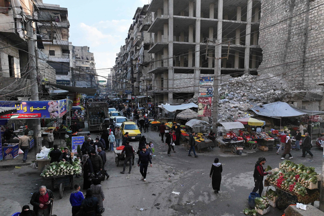 This aerial view shows people walking along a market street with collapsed buildings that were destroyed during the Syrian Civil War, in Syria's northern city of Aleppo on the first day of the Muslim holy fasting month of Ramadan on Saturday (AFP photo)