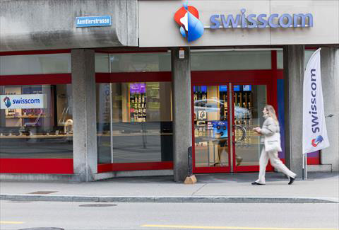 A woman walks past the logo of Swiss telecommunication company Swisscom is seen at a branch office in Zurich on Wednesday (AFP photo)