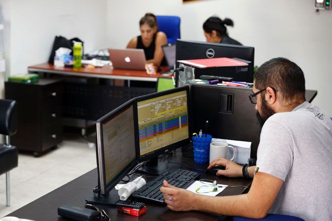 Palestinians work at the office of Red Crow, a start-up that monitors security developments and sends real-time alerts and maps to clients, in Ramallah  on August 17 (AFP photo)