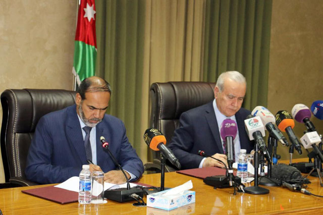 Minister of Education and Higher Education and Scientific Research Walid Maani (right) and Jordan Teachers Association Vice President Nasser Nawasrah on Sunday sign the agreement that ended teachers' nationwide strike that lasted for one month (Photo by Khaled Oudat)