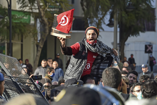 A Tunisian protester lifts a flag-clad birdcage during an anti-government demonstration on the Habib Bourguiba avenue in the capital Tunis, on Tuesday (AFP photo)